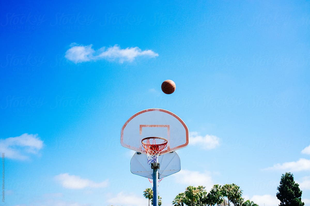 basketball in air shooting toward hoop